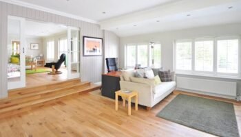 Spacious and bright modern living room with wooden floors and stylish furniture.